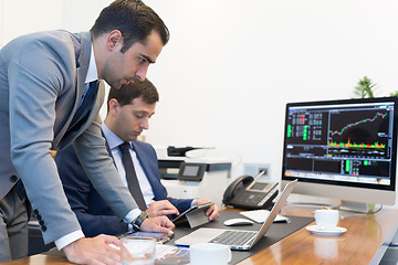 Image showing Business team remotely solving a problem at business meeting using laptop computer and touchpad.