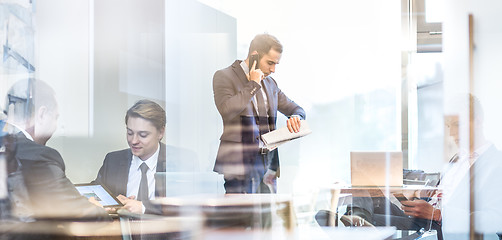 Image showing Businessman talking on a mobile phone on corporate office.