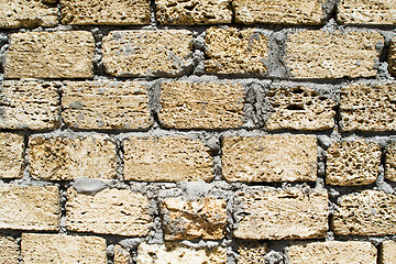 Image showing wall from a rough yellow brick. background