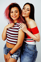 Image showing lifestyle people concept: two pretty stylish modern hipster teen girl having fun together, diverse nation mixed races, happy smiling making selfie closeup