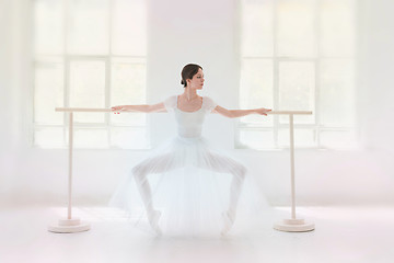 Image showing Young and incredibly beautiful ballerina is posing and dancing in a white studio