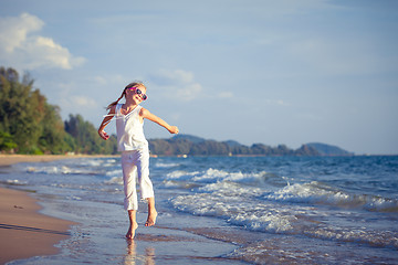 Image showing Little girl  dancing on the beach at the day time.