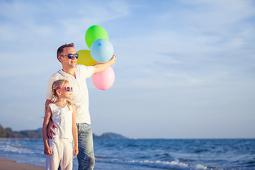 Image showing Father and daughter playing on the beach at the day time.