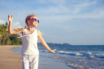 Image showing Little girl  dancing on the beach at the day time. 