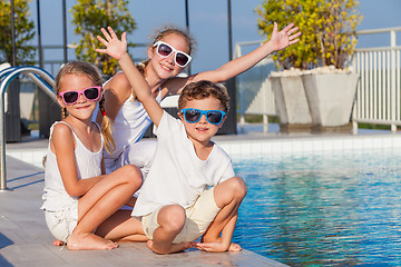 Image showing happy children  playing on the swimming pool at the day time.