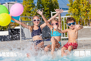 Image showing happy children  playing on the swimming pool at the day time.