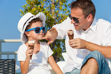 Image showing Father and son relaxing near a swimming pool  at the day time.