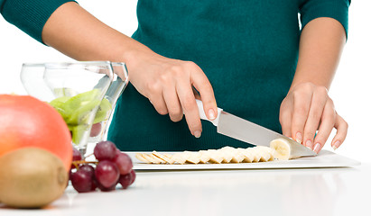 Image showing Cook is chopping banana for fruit dessert