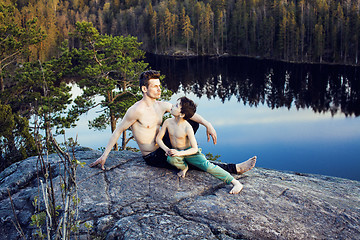 Image showing middle age man with little cute son doing sport yoga on the top of the mountain together, happy family lifestyle people outdoor, summer wild nature for training