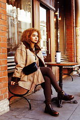 Image showing young pretty african american women drinking coffee outside in c