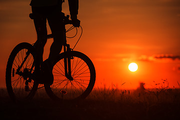 Image showing Silhouette of a bike on sky background during sunset