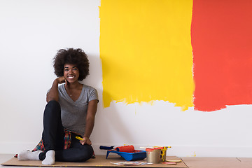 Image showing back female painter sitting on floor