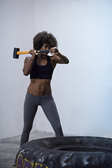 Image showing black woman workout with hammer and tractor tire