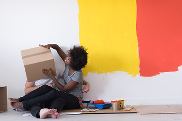 Image showing young multiethnic couple playing with cardboard boxes