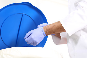 Image showing Medical waste, surgeon dropping the gloves in a special container for waste 