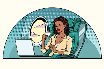 Image showing African Businesswoman in business class of the aircraft works at