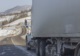 Image showing Speeding truck wheels on icy road during winter storm