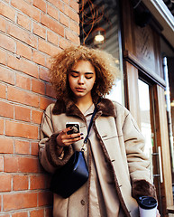 Image showing young pretty african american women drinking coffee outside in c