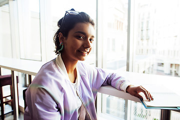 Image showing young cute hipster girl student sitting in cafe with notebook re