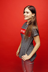 Image showing young pretty emitonal posing teenage girl on bright red background, happy smiling lifestyle people concept