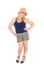 Image showing Woman standing in shorts and straw hat.