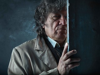 Image showing The senior man as detective or boss of mafia on gray studio back