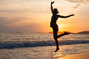 Image showing Happy girl jumping on the beach