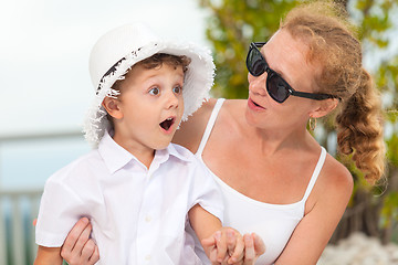 Image showing Mother and son relaxing near a swimming pool  at the day time.