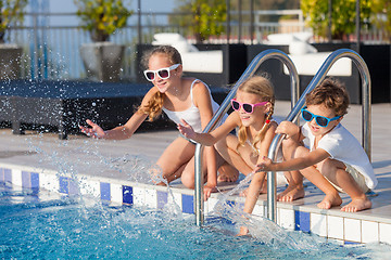 Image showing happy children  playing on the swimming pool at the day time.