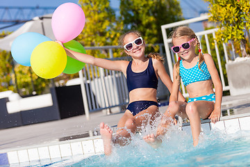 Image showing Two happy children  playing on the swimming pool at the day time