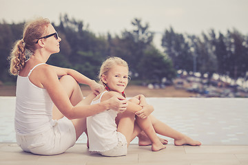 Image showing Mother and daughter relaxing near a swimming pool  at the day ti