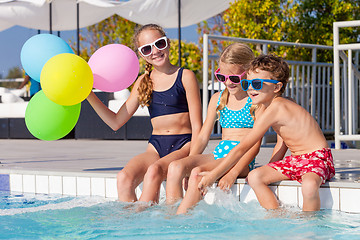 Image showing happy children  playing on the swimming pool at the day time.