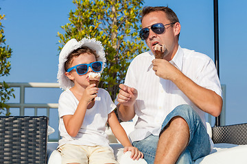 Image showing Father and son relaxing near a swimming pool  at the day time.