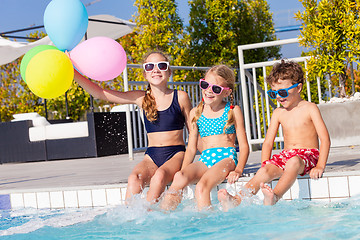 Image showing happy children  playing on the swimming pool at the day time.