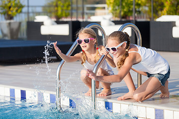 Image showing Two happy children  playing on the swimming pool at the day time