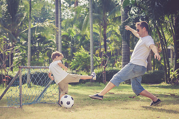 Image showing Father and son playing in the park  at the day time.