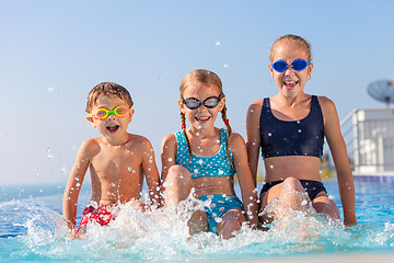 Image showing happy children  playing on the swimming pool at the day time.