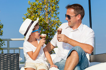 Image showing Father and son relaxing near a swimming pool  at the day time.