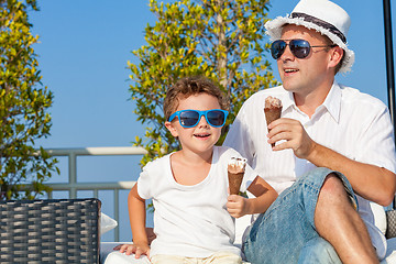 Image showing Father and son relaxing near a swimming pool  at the day time.