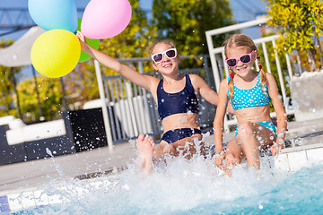 Image showing Two happy children  playing on the swimming pool at the day time