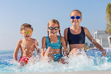 Image showing happy children  playing on the swimming pool at the day time.