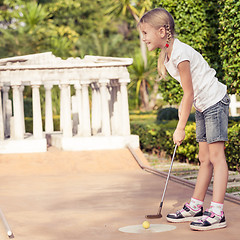 Image showing Little girl swinging golf club