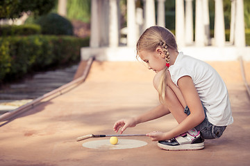 Image showing Little girl swinging golf club