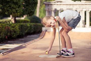 Image showing Little girl swinging golf club