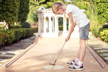 Image showing Little girl swinging golf club