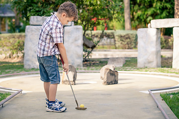 Image showing Little boy swinging golf club