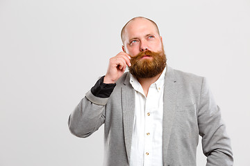 Image showing Thoughtful man holds his mustache