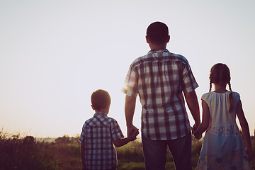 Image showing Father and children playing in the park at the sunset time.