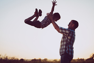 Image showing Father and son playing in the park at the sunset time.