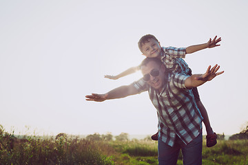 Image showing Father and son playing in the park at the sunset time.